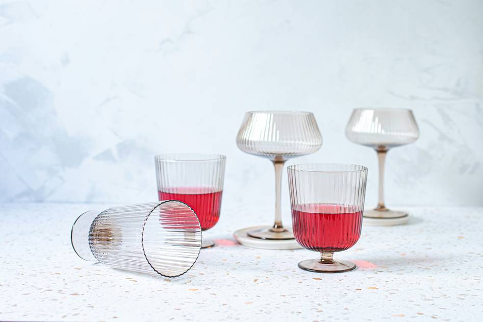 Close-up of elegant double-wall insulated wine glasses on reclaimed wood with green foliage accents