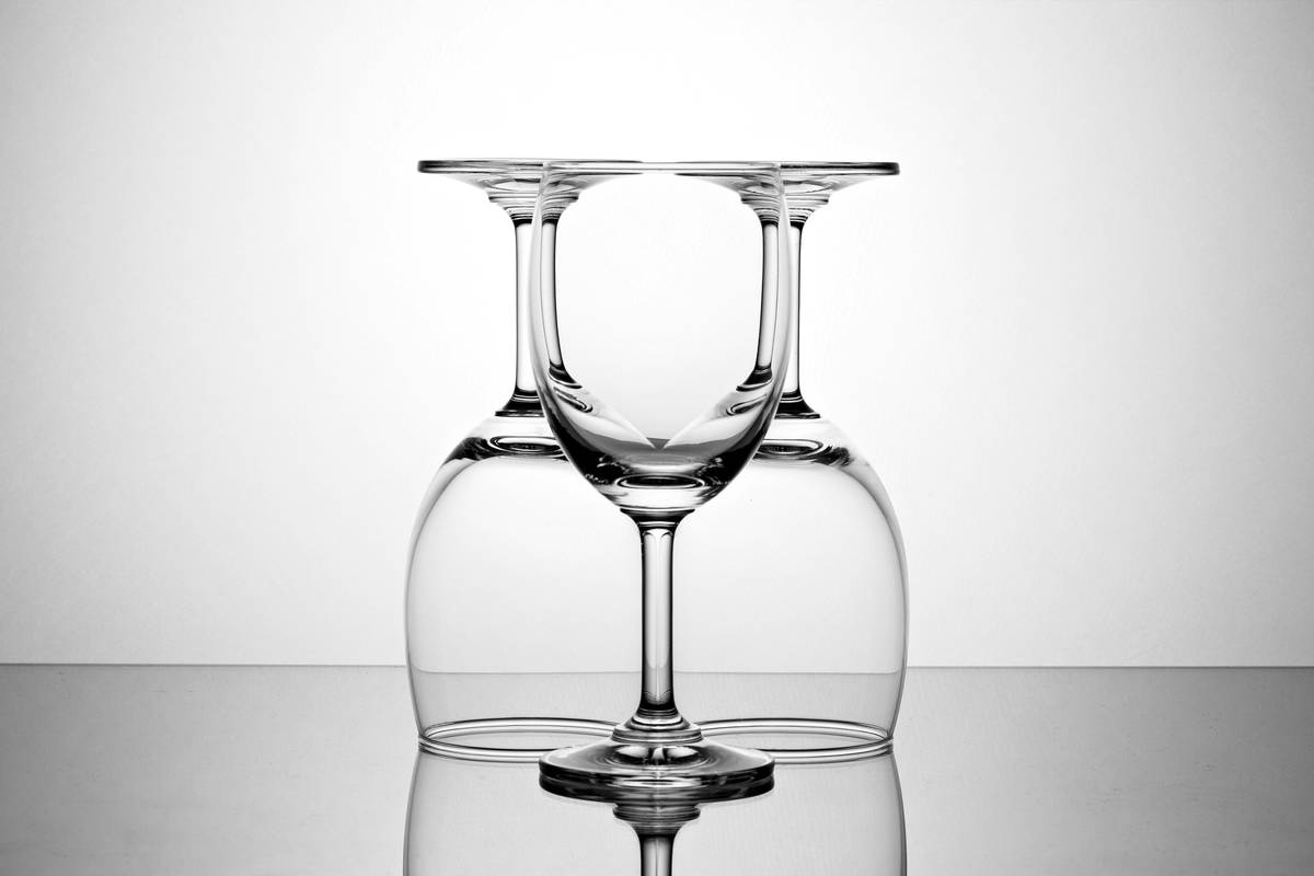 Set of recycled glass wine glasses on a wooden table showing condensation-free exterior due to double-wall insulation